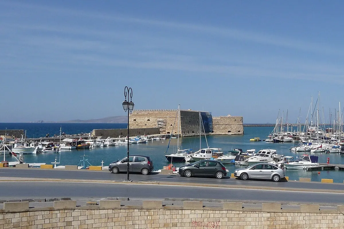 Die venezianische Seefestung an der Einfahrt zum alten Hafen von Heraklion, im Vordergrund vertäute Boote und eine Uferstraße